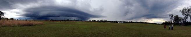 Széles panoráma-kép, a szélén a család áll esőkabátban, ámulatban a látványtól.